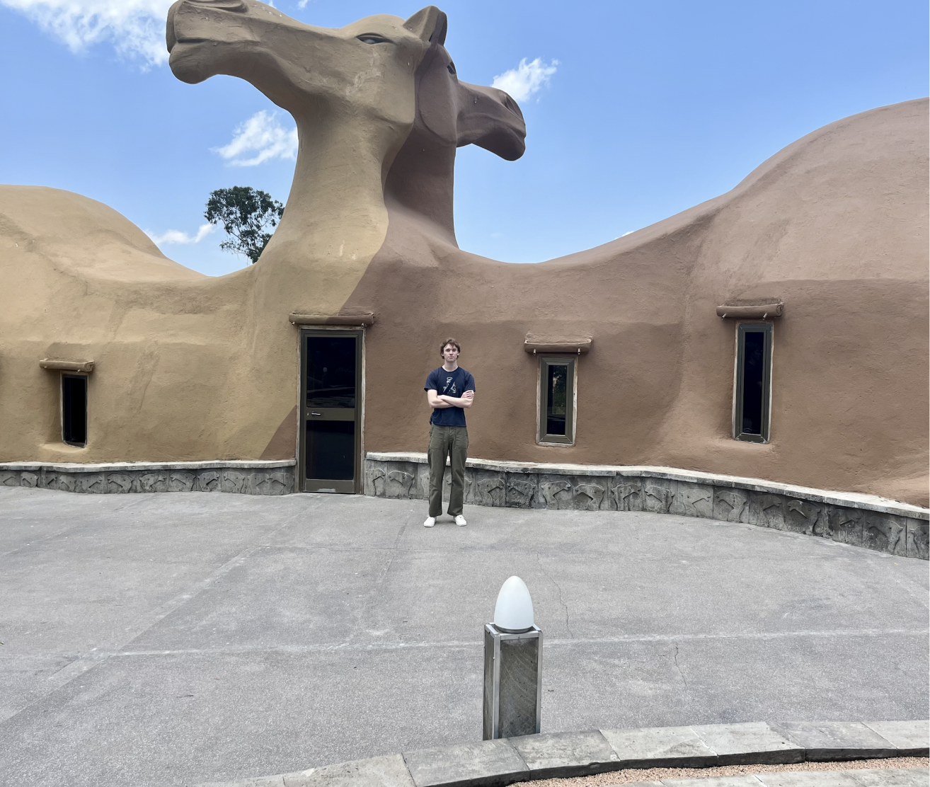 Gunner standing in front of a camel-shaped building in Ethiopia.